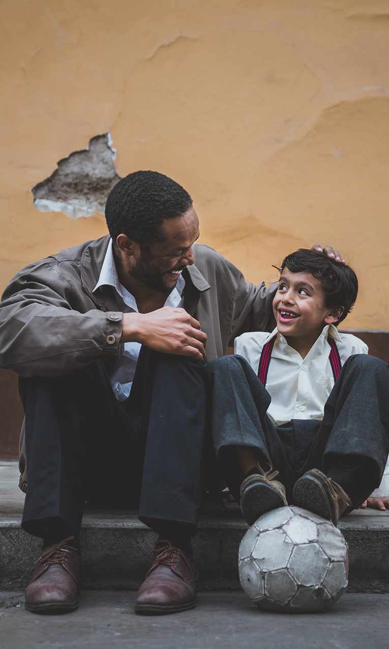 man smiling happily at his infant son