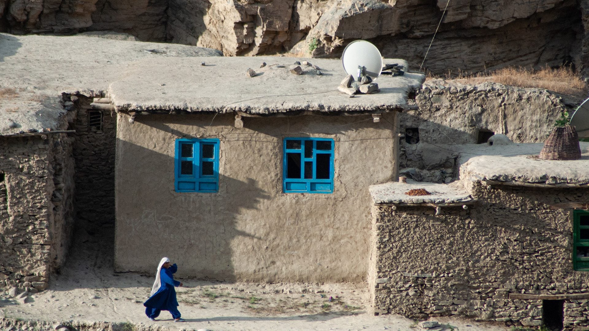 woman walking on dirt road in afghanistan