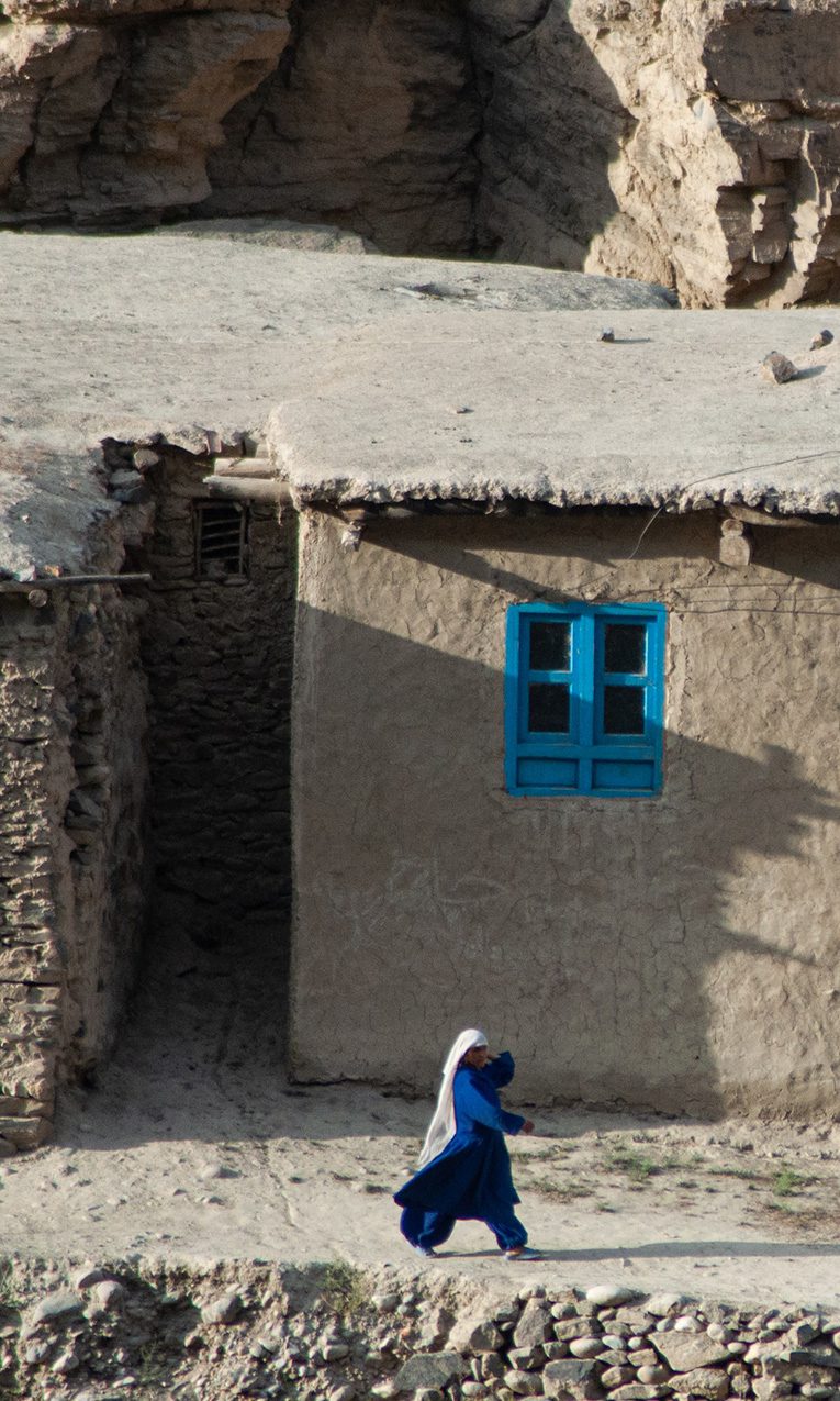 woman walking on dirt road in afghanistan