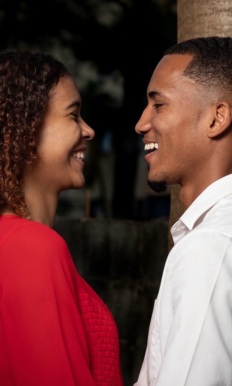 couple (male & female) smiling happily while facing each other