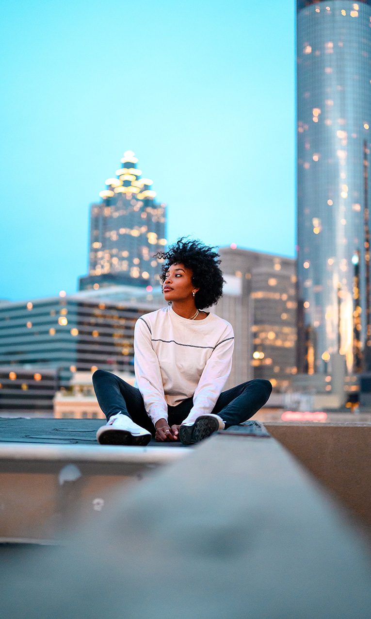 photo of a woman sitting in a rooftop in the city