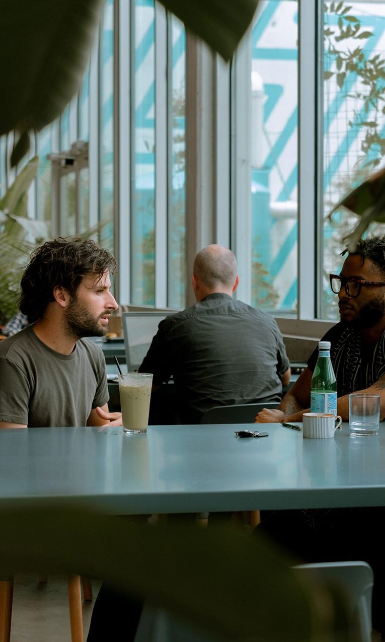 two men sitting at a table having a conversation