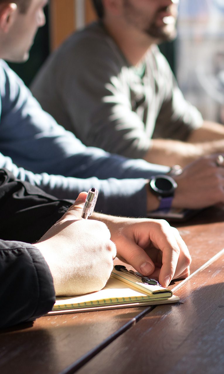 group of men taking notes during a meeting