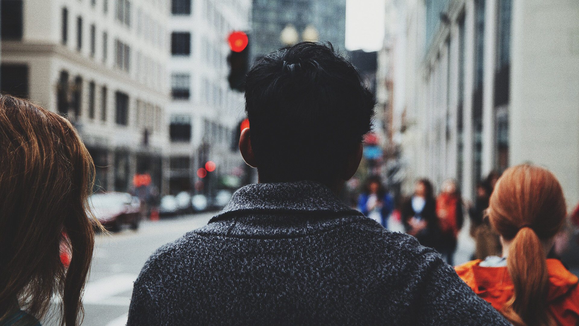 man on road along concrete buildings during daytime