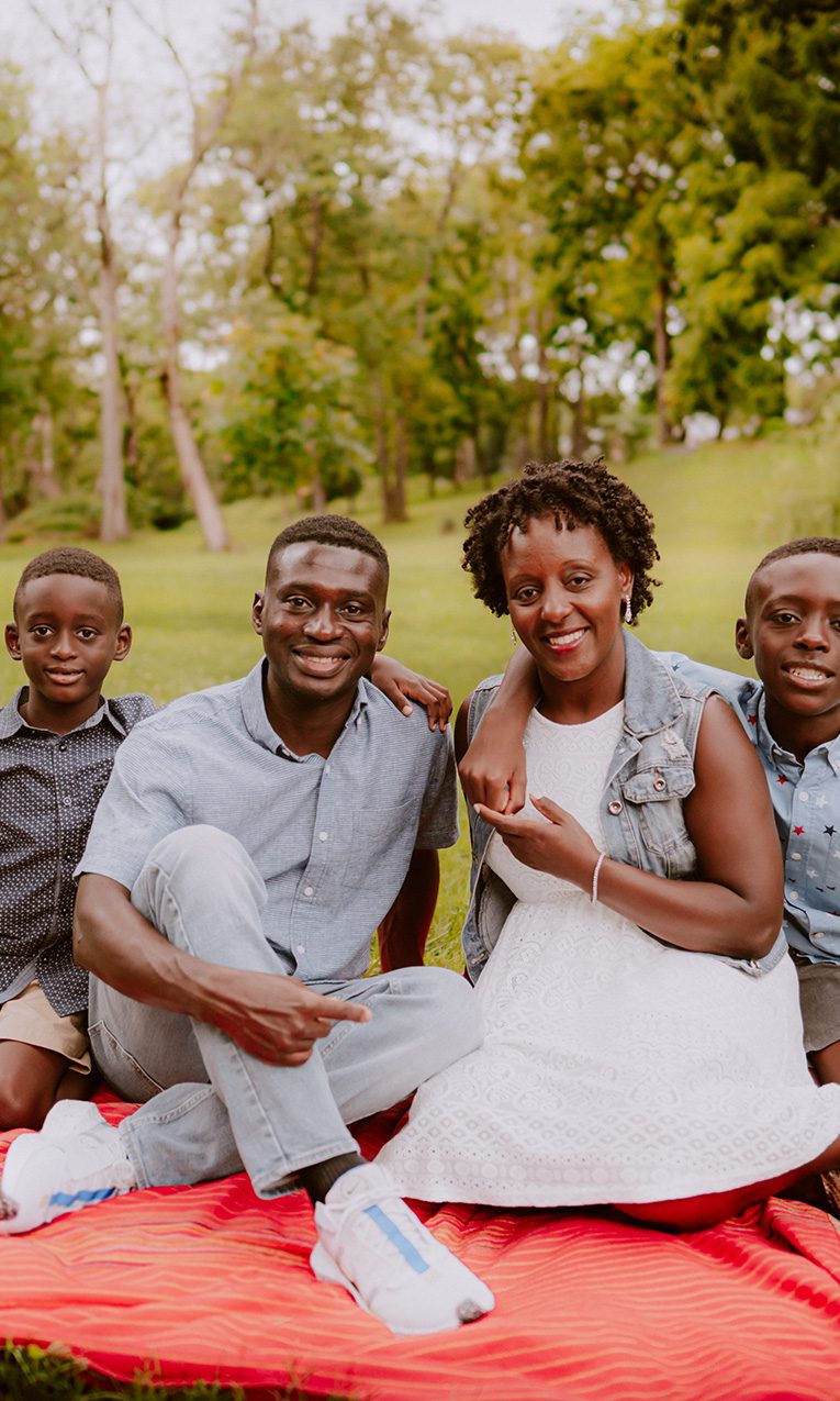 family sitting on green grass field during daytime
