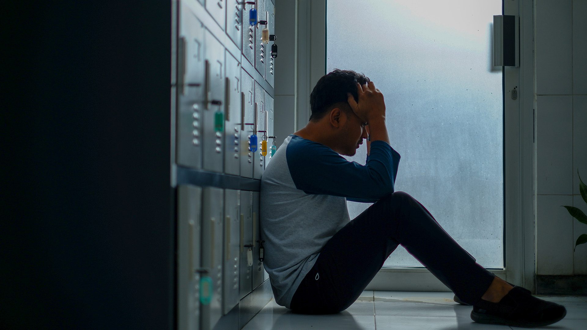 a man sitting on the floor looking discouraged