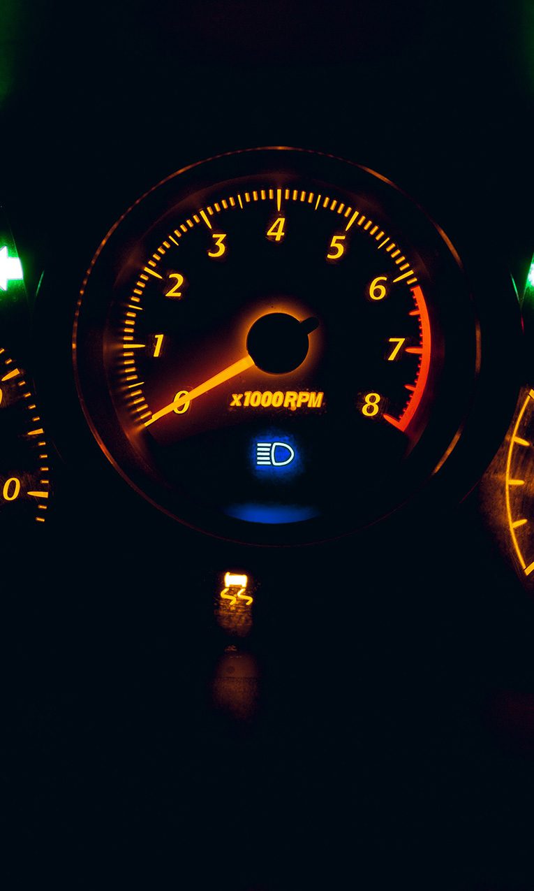 photo of a black and yellow analog speedometer