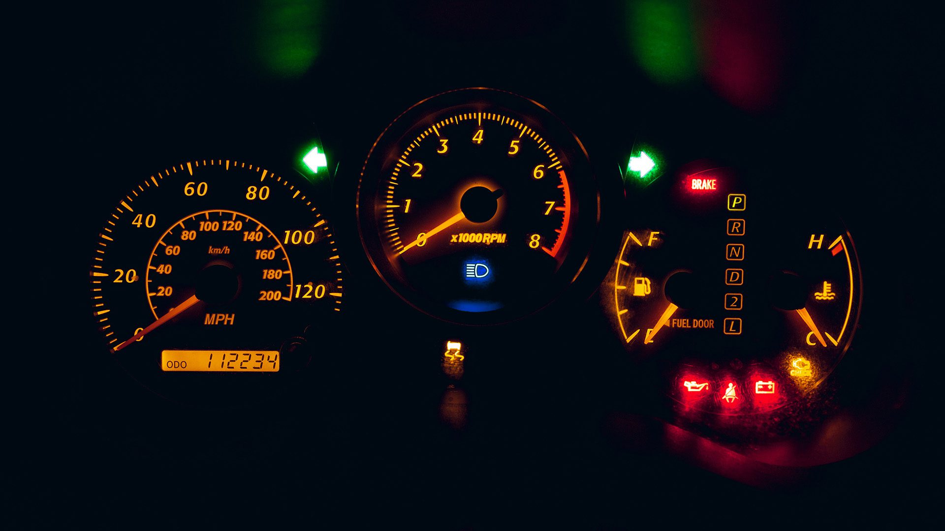 photo of a black and yellow analog speedometer