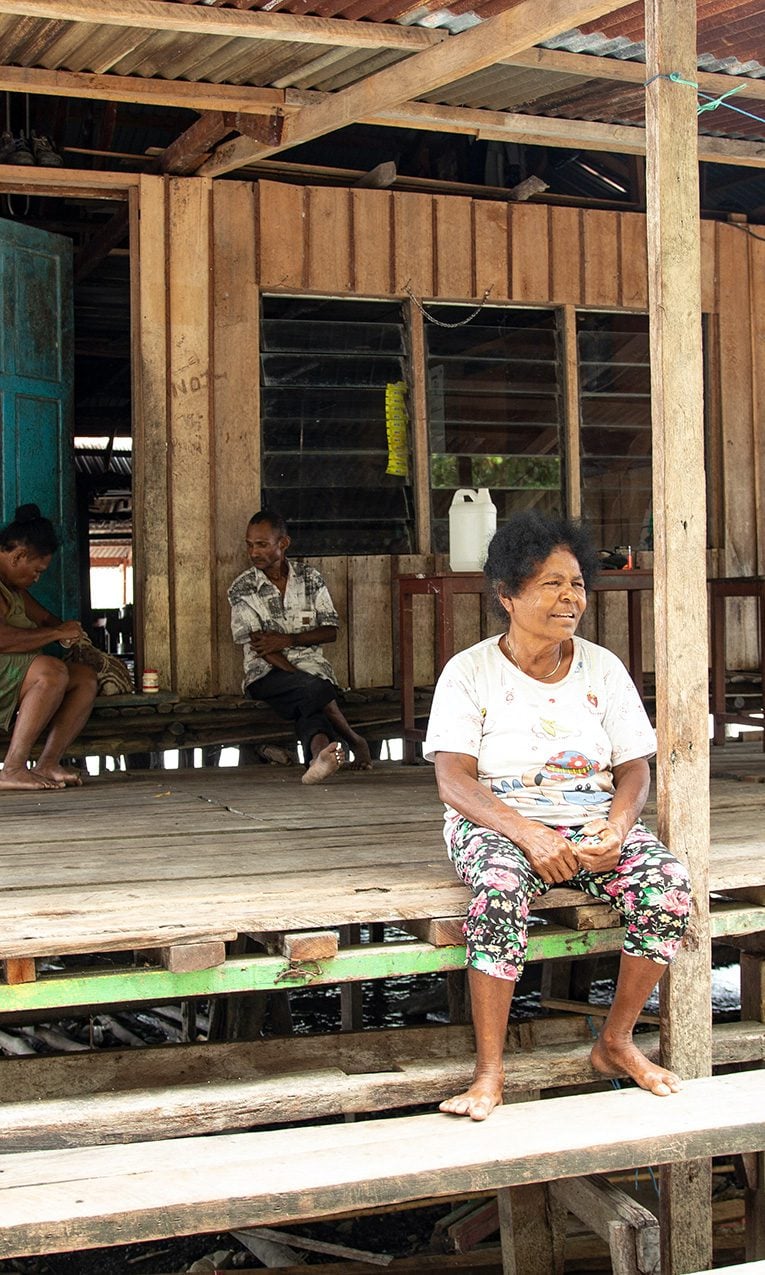 people sitting on a wooden deck in Papua New Guinea
