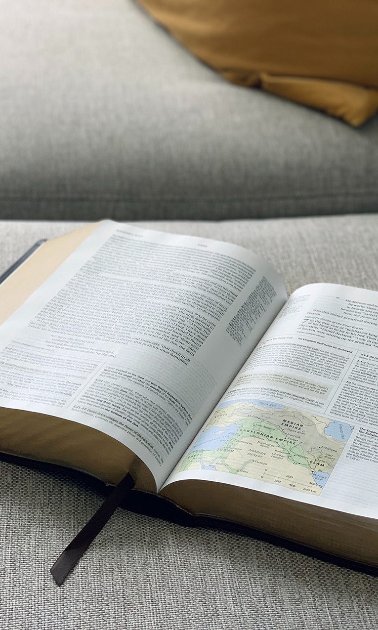 open Bible on top of a gray sofa