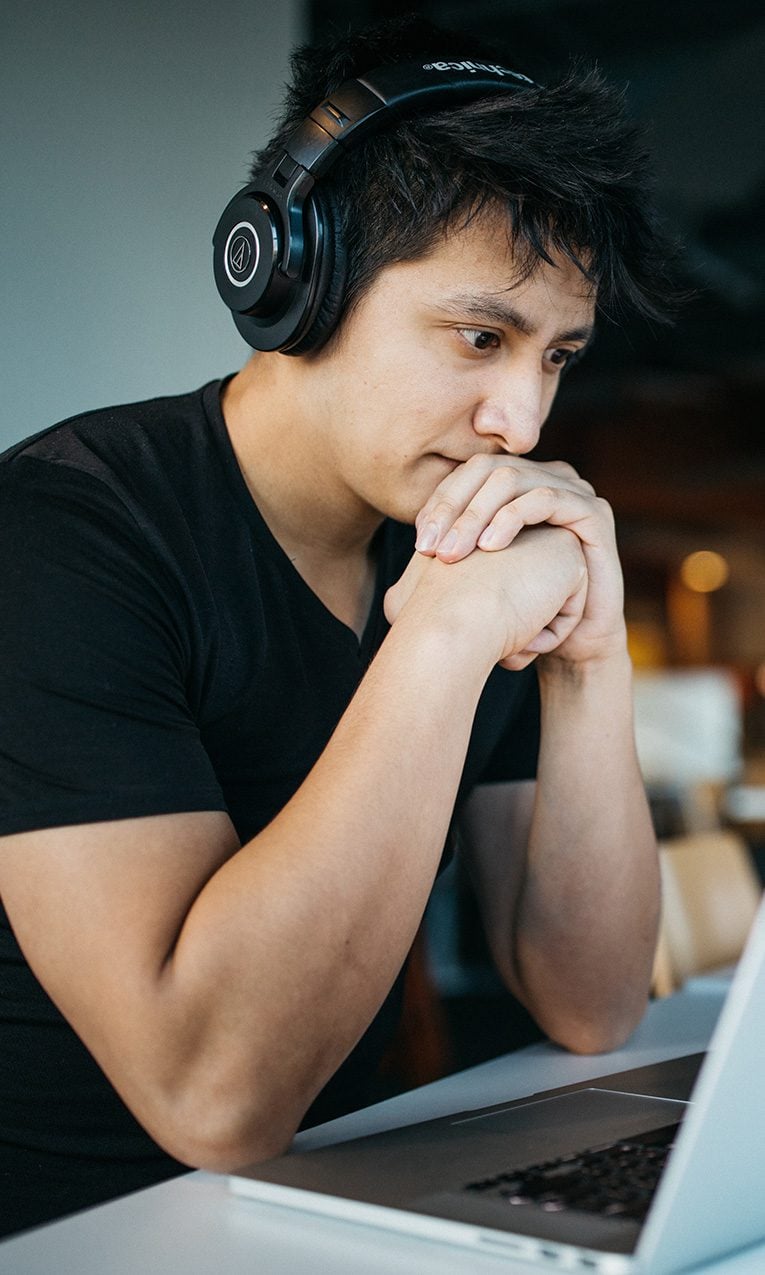 man wearing headphones while sitting on a chair