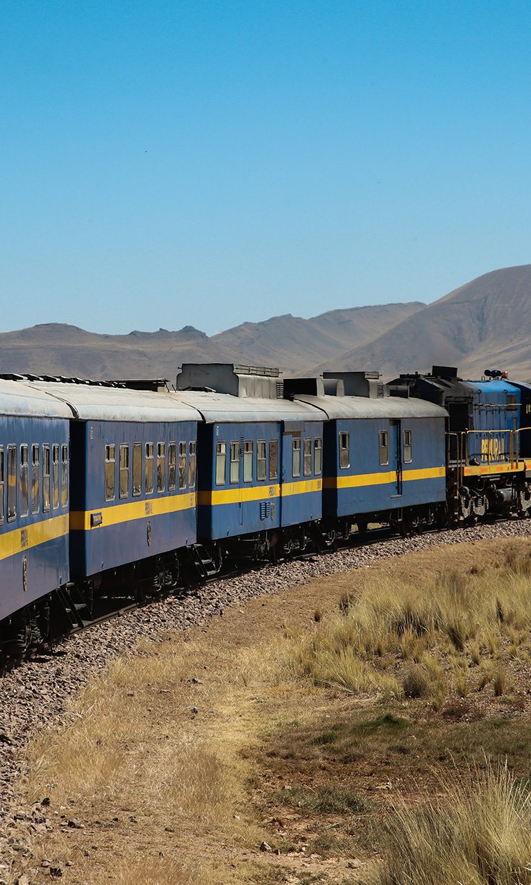 blue train moving through mountains