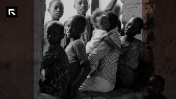 photo of children gathered around their mother sitting on a wall