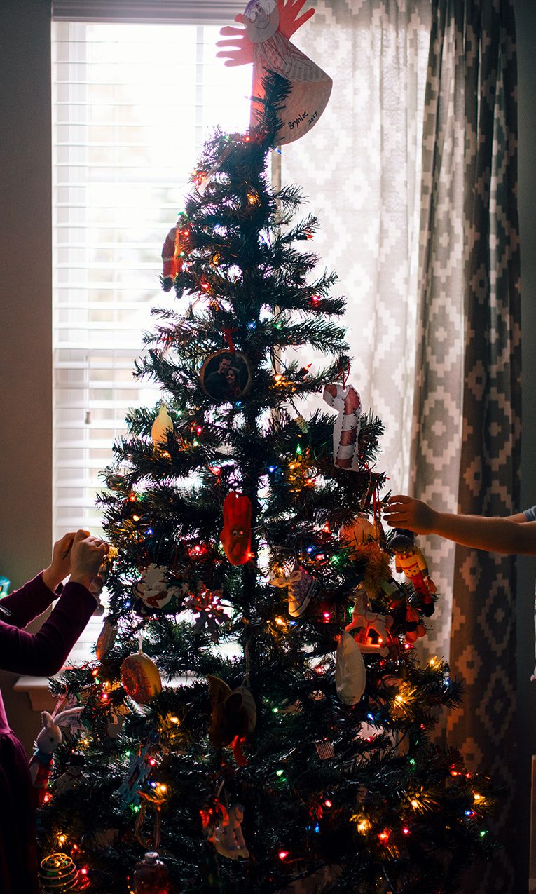 Girl and boy standing near Christmast tree