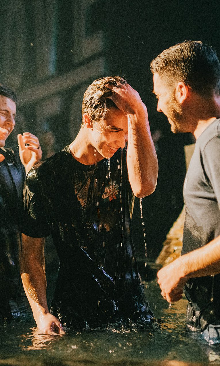two men helping celebrating a friend's baptism