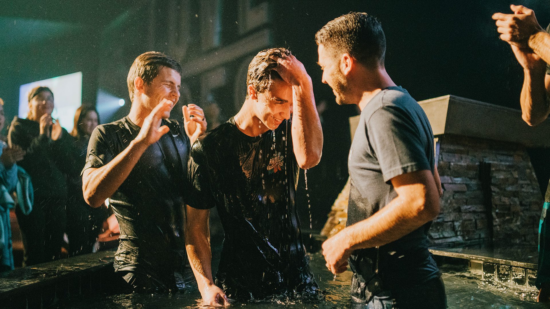 two men helping celebrating a friend's baptism