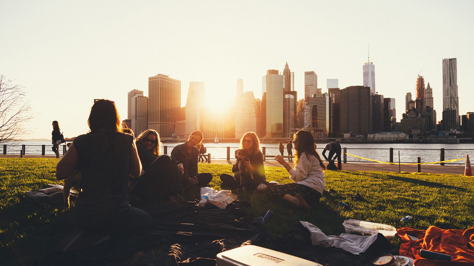 young adults having a picnic at the park during sunset