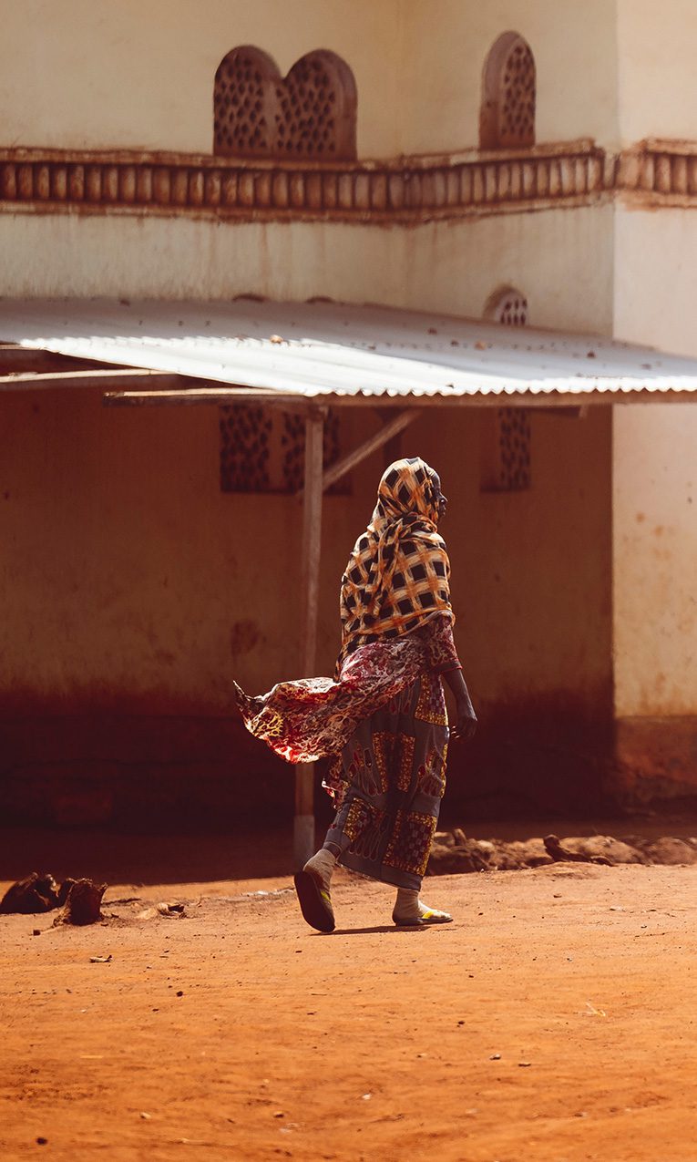 Woman walking on a dusty road on the Ivory Coast of West Africa.