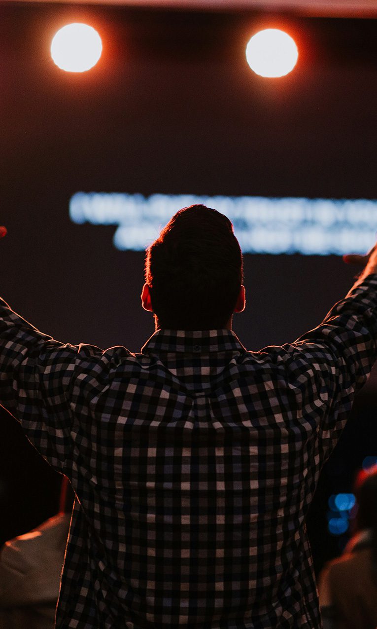 man raising his hands in worship
