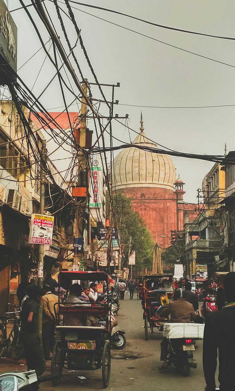 people in the street near a mosque in Chandi chowk, Delhi, India