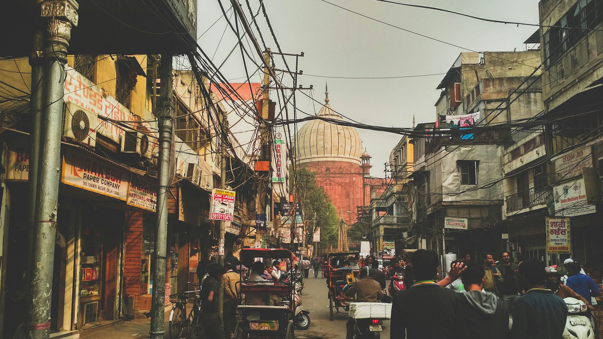 people in the street near a mosque in Chandi chowk, Delhi, India