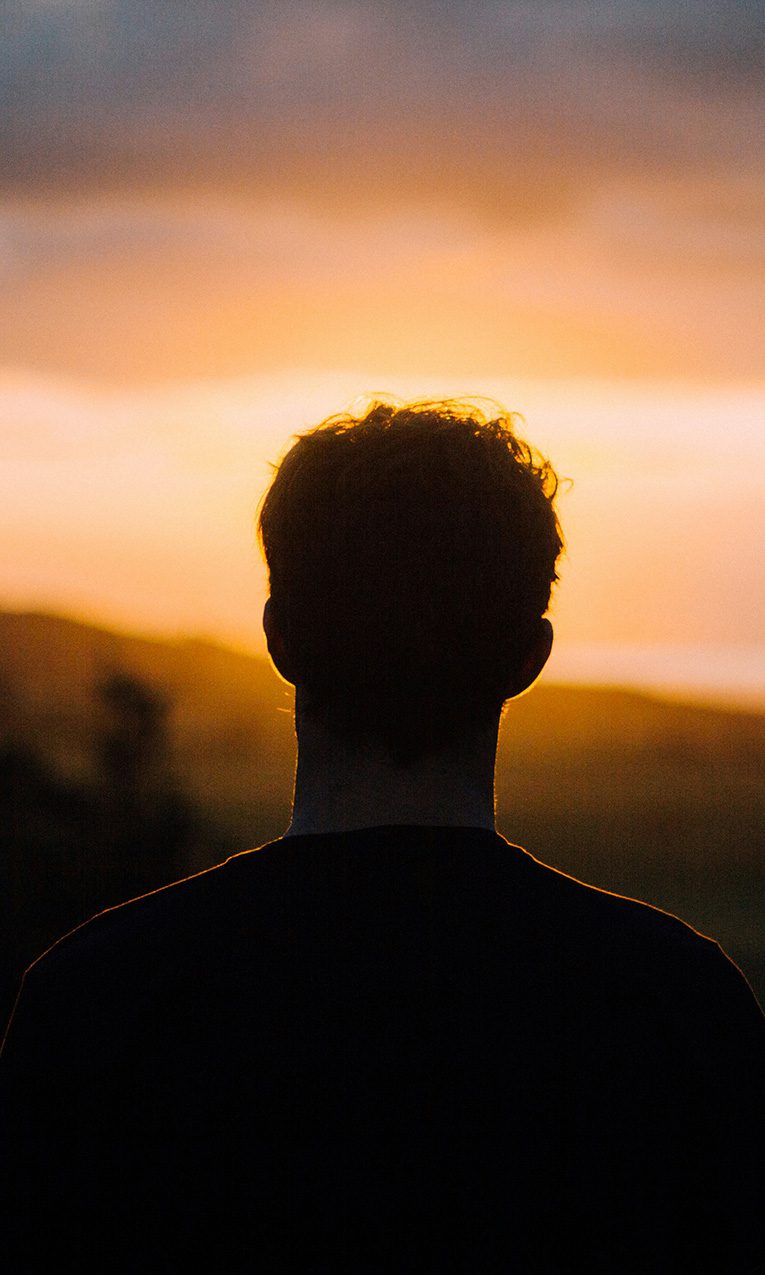 silhouette of a man facing the sunset