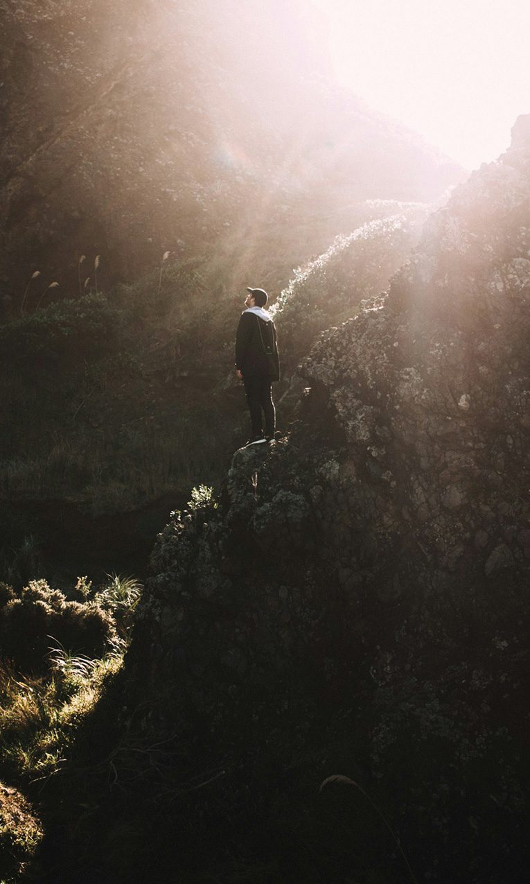 man standing on rock mountain during daytime