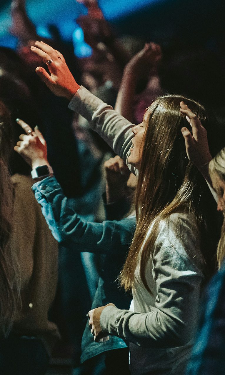 people raising their hands in worship at church