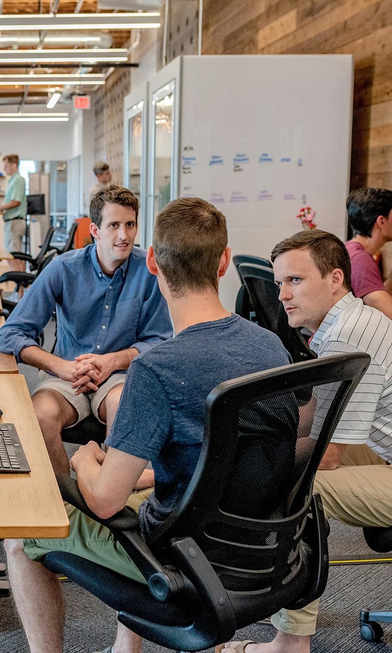 three men having a conversation in a collaborative workspace
