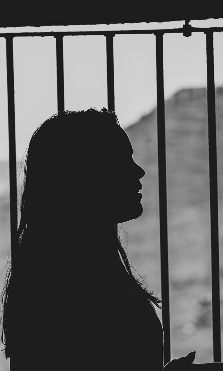 a woman behind prison bars