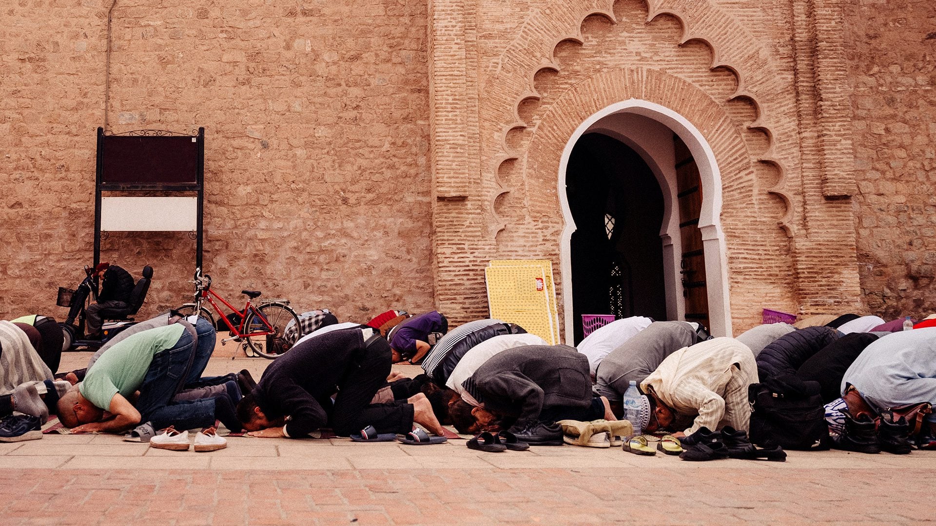 Muslim men kneeled in prayer