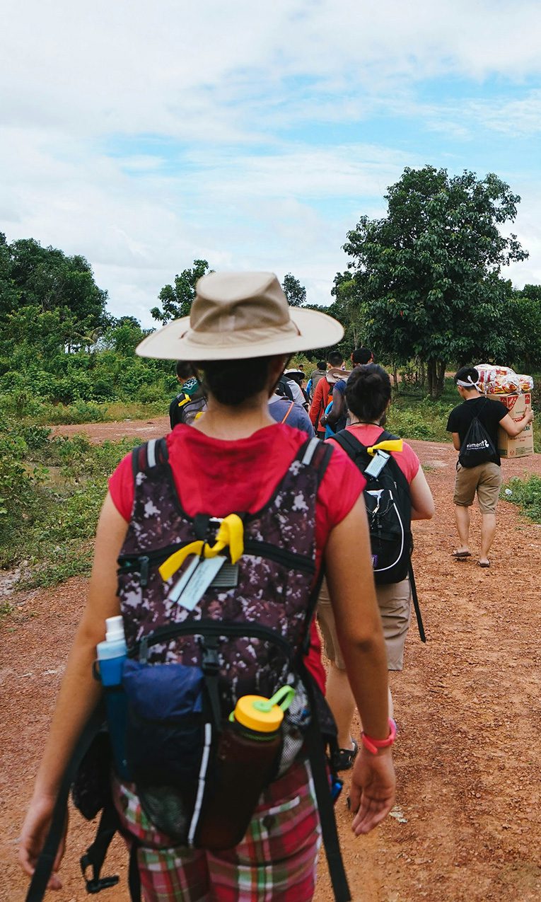 people walking on a dirt road in a remote village