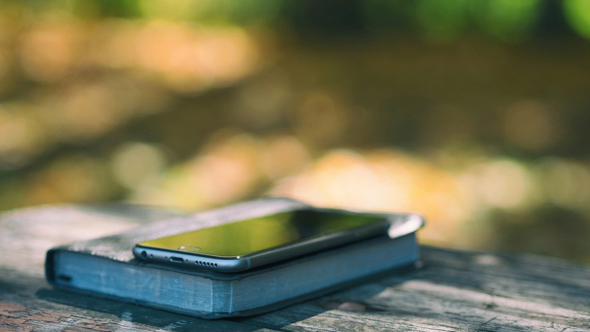 a phone on a Bible laid on a table