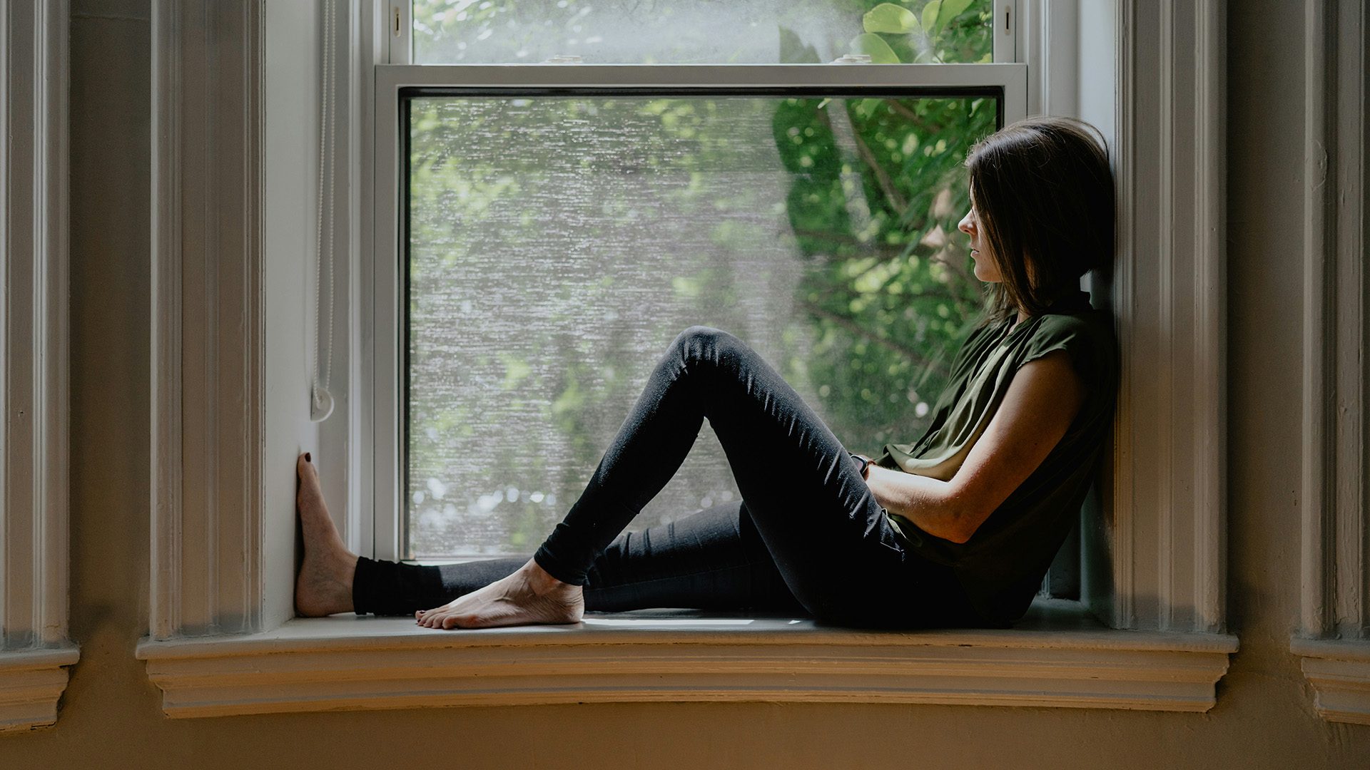 a woman sitting by a window