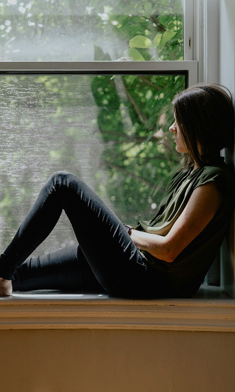a woman sitting by a window