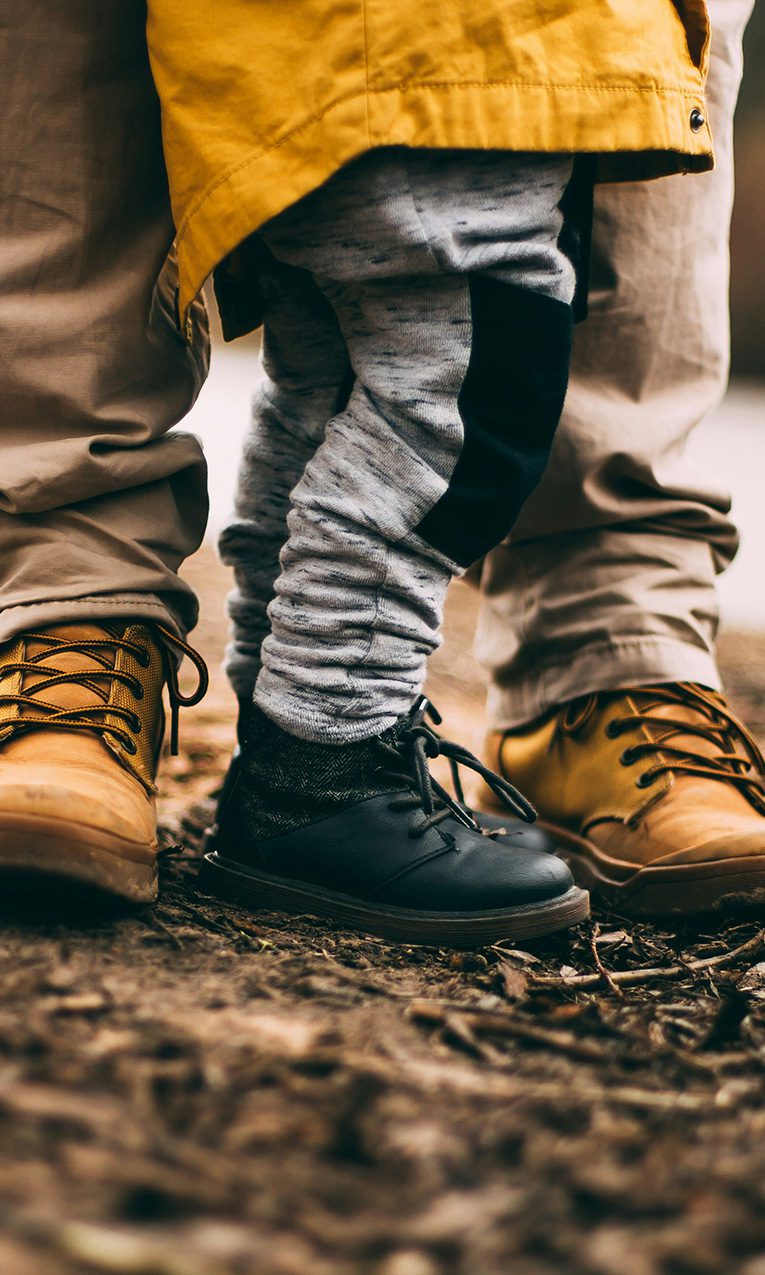 a child standing next to his dad