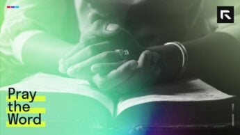 A woman's hands folded in prayer over a Bible.
