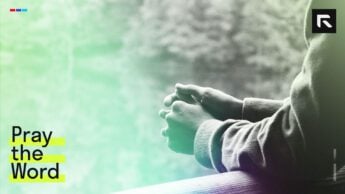 A man praying near a lake.
