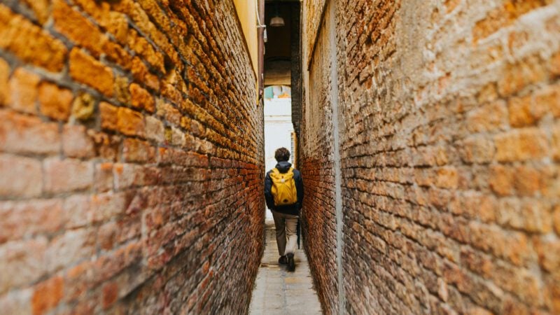A man walking in an alley.
