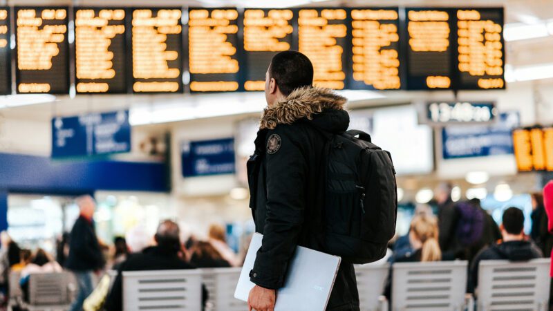 A man standing at a boarding gate in the airport.