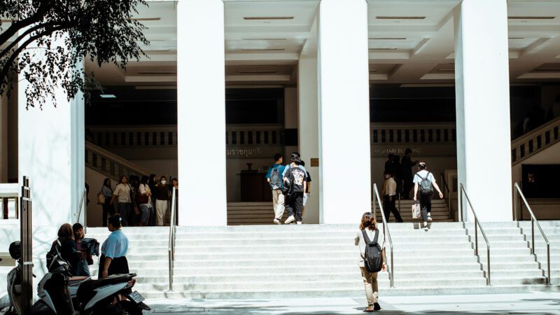 Young adults walking to class on a college campus.