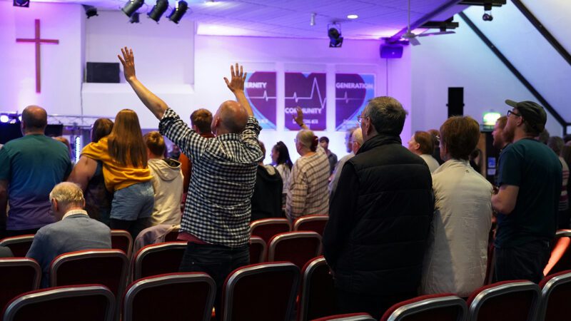 Congregation of people worshipping in a church.