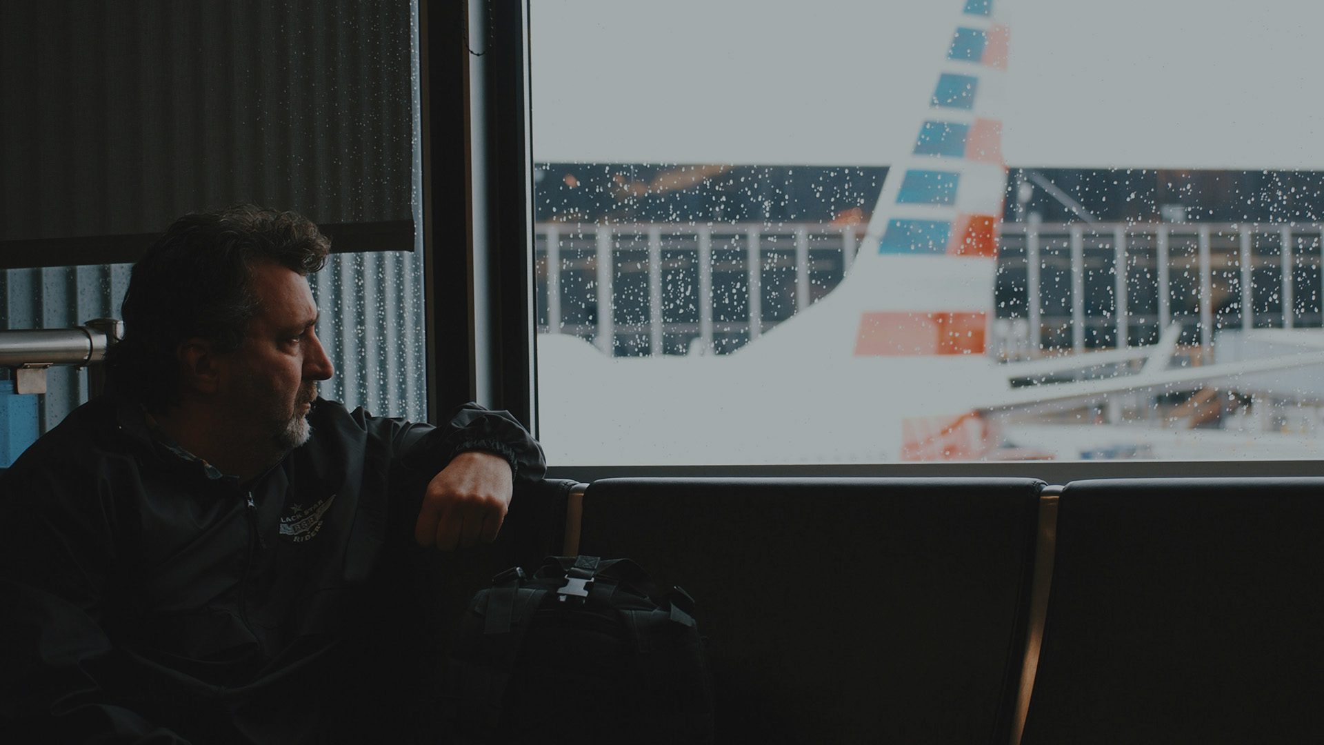 A man sitting by an airport window.