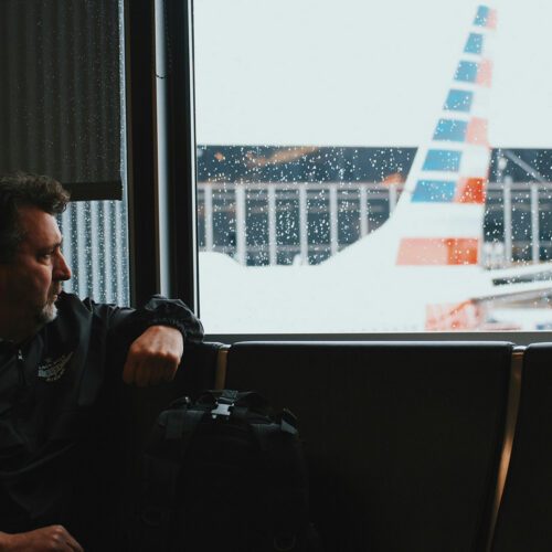 A man sitting by an airport window.
