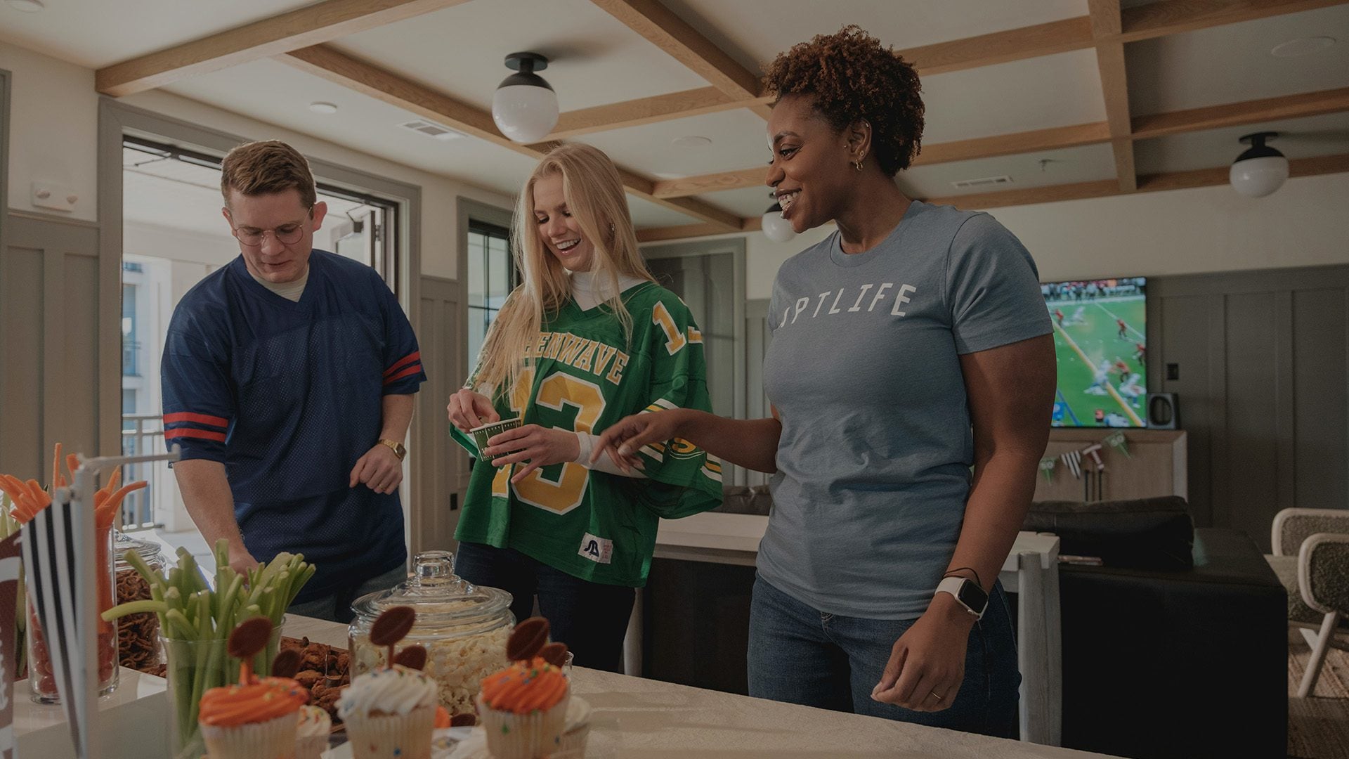 Three friends gathered around a table with snacks.