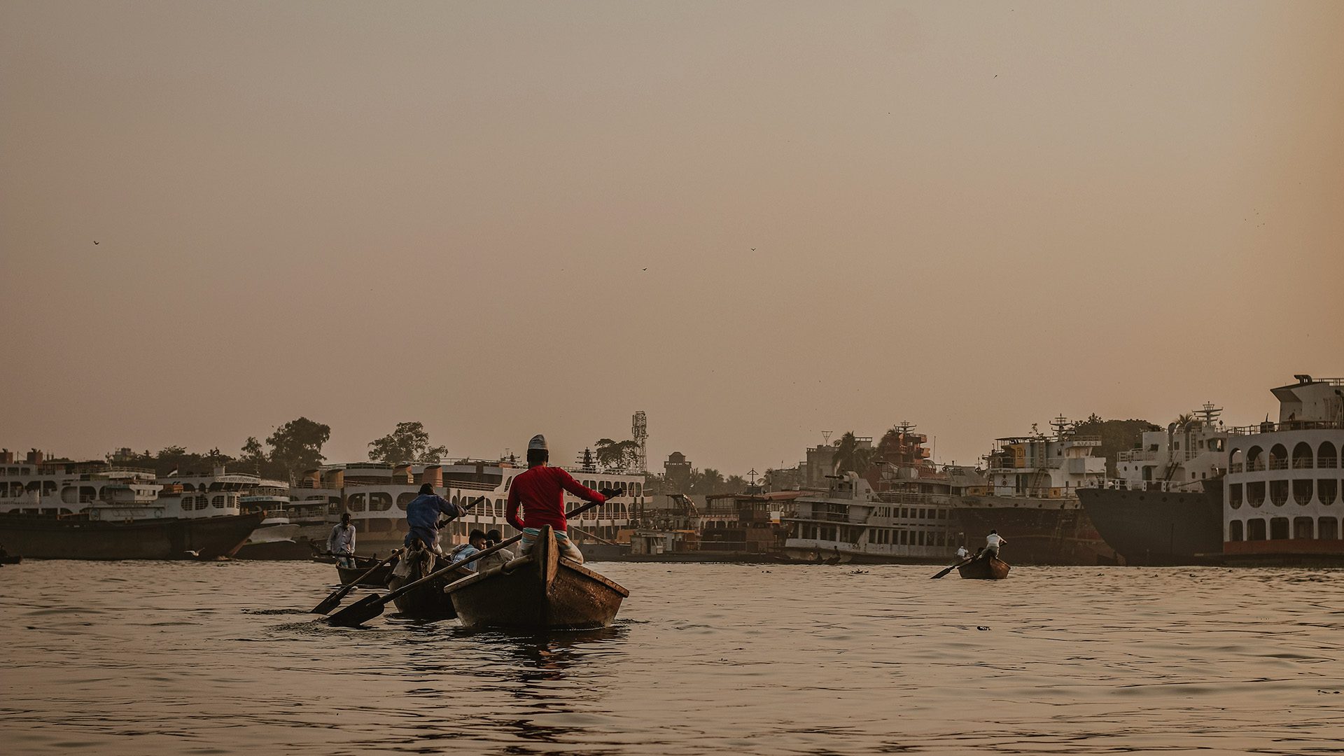 Man in red shirt riding on boat during daytime.