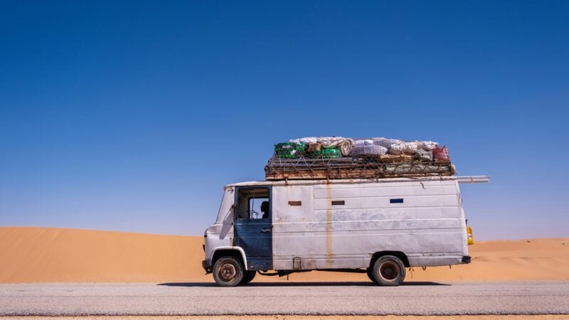 A solitary van traveling through the endless Mauritanian desert.